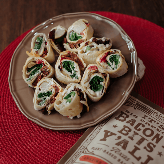 A platter of colorful vegan pinwheels featuring All Y’alls Foods’ Big Crunchy Cheezy Bits and fresh vegetables, perfect for snacking or sharing, from https://allyallsfoods.com/.