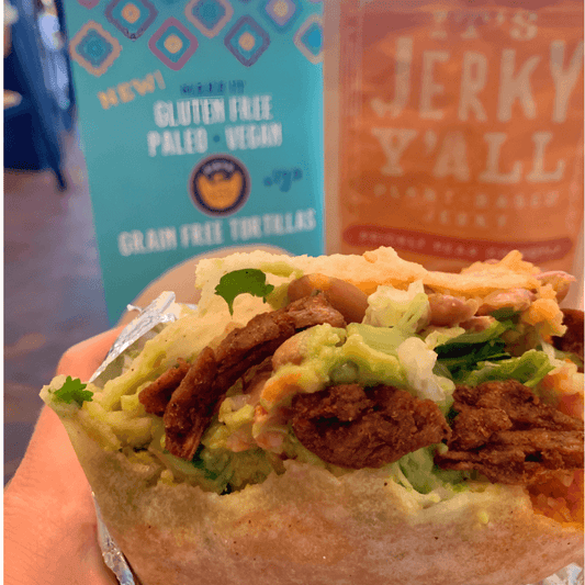 A fresh, loaded burrito packed with greens, guacamole, and Prickly Pear Chipotle vegan jerky, delivering a sweet and slightly spicy plant-based twist.