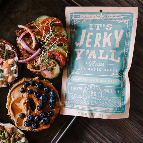  A vibrant display of bagels topped with fresh veggies, peanut butter, blueberries, and plant-based jerky from https://allyallsfoods.com/.