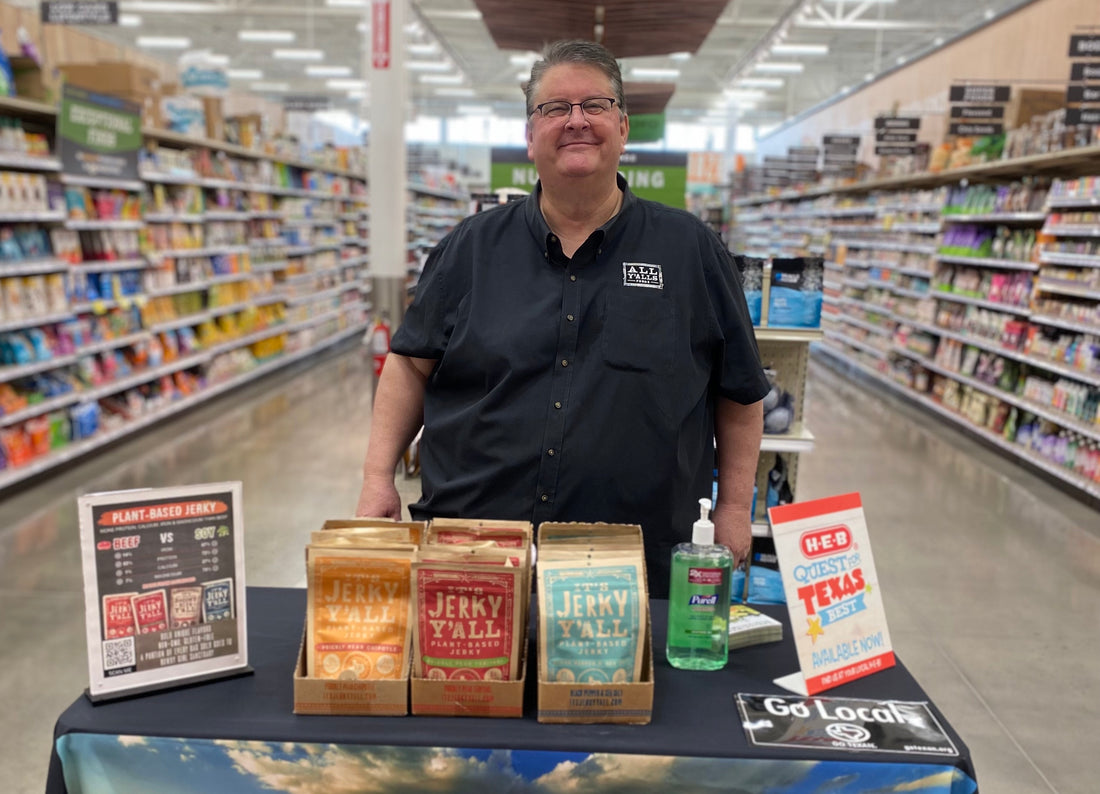CEO Brett at a table with vegan jerky to sample in a grocery store