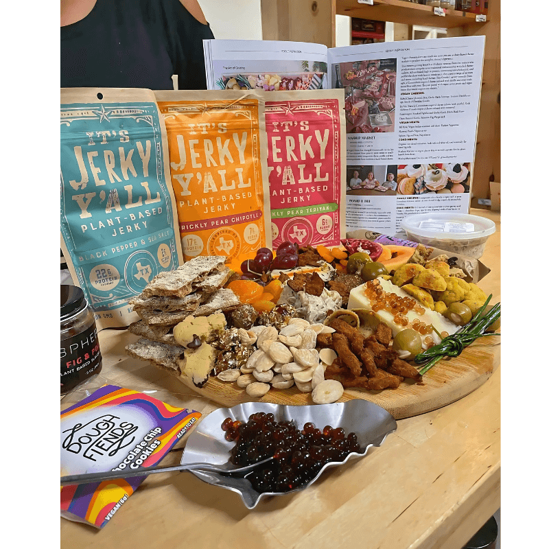 A beautifully arranged plant-based charcuterie board showcasing plant jerky alongside fresh produce, nuts, vegan cheese, and accompaniments, perfect for gatherings or entertaining.