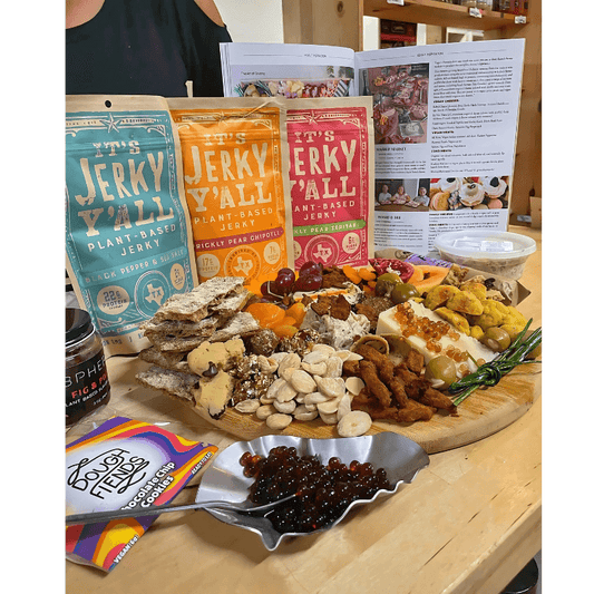 A beautifully arranged plant-based charcuterie board showcasing plant jerky alongside fresh produce, nuts, vegan cheese, and accompaniments, perfect for gatherings or entertaining.