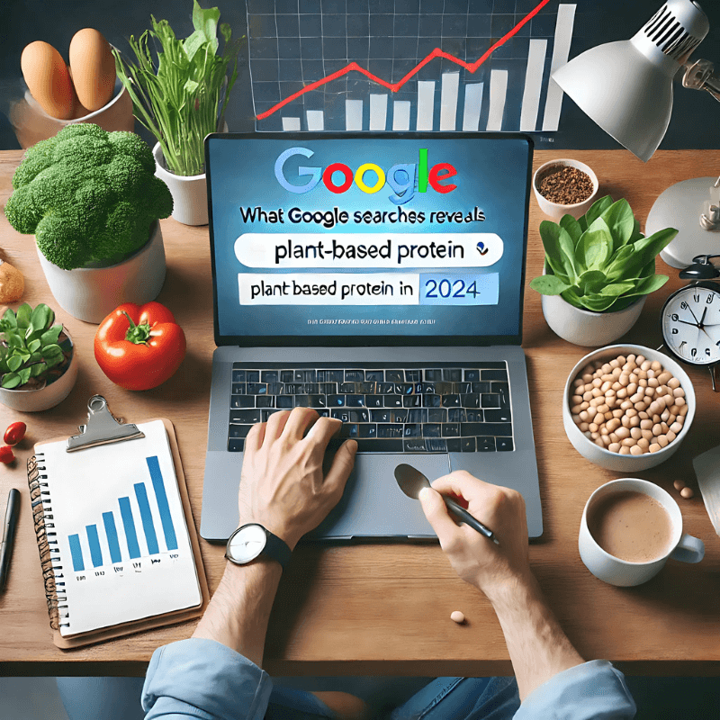 A professional workspace featuring a laptop displaying Google searches on plant-based protein alongside fresh vegetables and a modern setup, emphasizing plant jerky trends in 2024.