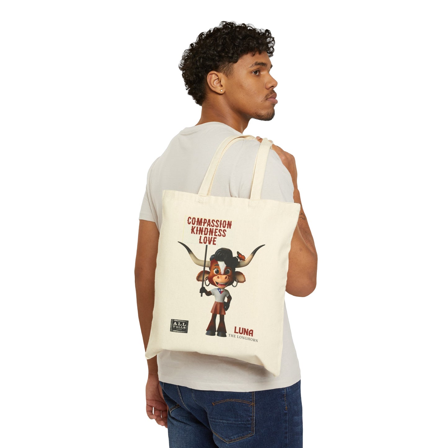 Man carrying a cotton canvas tote bag featuring Luna the Longhorn and the message 'Compassion, Kindness, Love,' showcasing a durable and stylish canvas tote bag perfect for everyday use.